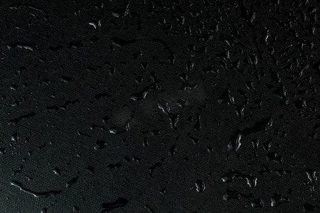 科技水滴摄影照片_带水滴的黑色平橡胶表面宏观背景