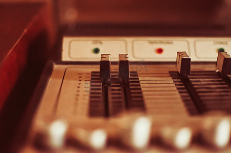 DJ 播放器的特写混音器、音响设备、复古风格的乙烯基播放器的声音控制面板，用于立体声、复古色调、选择性聚焦。 