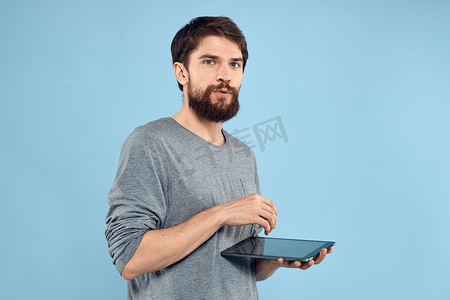 手拿平板电脑技术生活方式无线设备蓝色背景的人