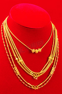 项链展示架，红色天鹅绒面料上配有金项链。