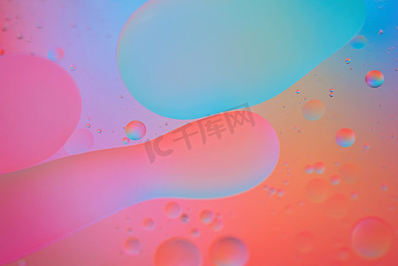 用油、水和肥皂制作的红色、粉色和蓝色抽象背景图片
