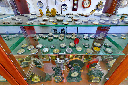 钟表金色摄影照片_玻璃后面收藏着各种怀表。