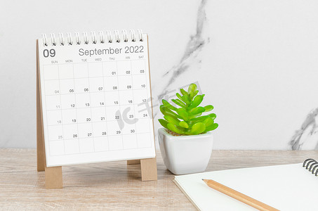 2022 年 9 月台历，木桌上有植物。