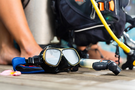 潜水长和学生在潜水员课程中穿着潜水服或在前台潜水，前景是氧气罐
