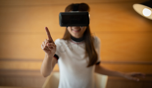 在 VR 体验中接触空气的年轻亚洲女性