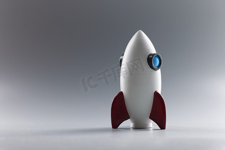 火箭玩具模型站在灰色表面，火箭飞船作为商业项目的象征