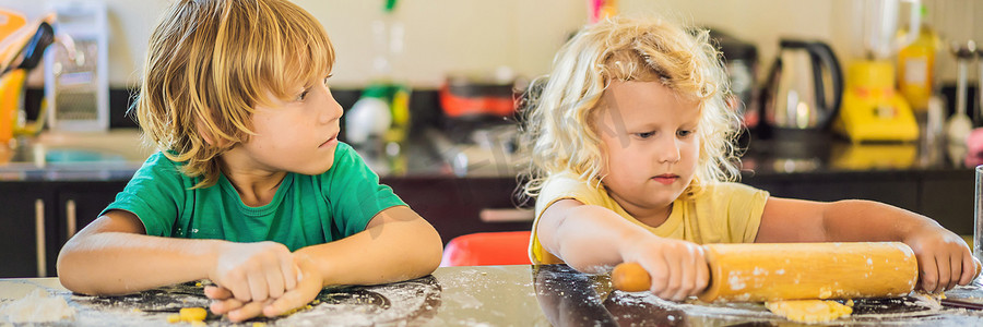 两个孩子一个男孩和一个女孩用面团做饼干 BANNER, LONG FORMAT