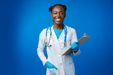 蓝色工作室带剪贴板的快乐非洲医学实习女医生肖像