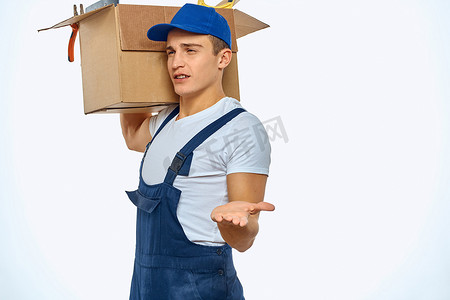 正在加载摄影照片_一个穿着工作制服、手里拿着一个盒子的男人正在加载送货服务