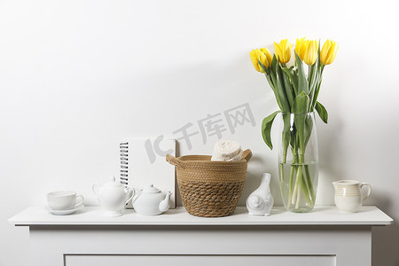 白桌玻璃花瓶中的黄色郁金香花束
