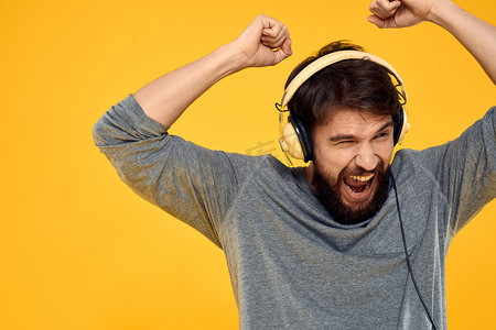 戴耳机音乐生活方式生活方式科技黄色背景的男人
