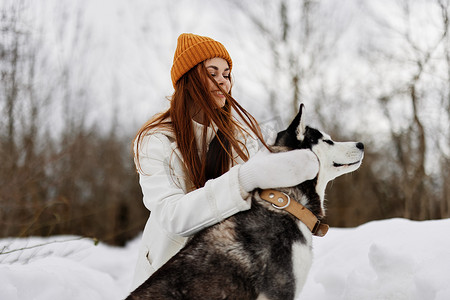 开朗的女人穿冬装在雪地里遛狗 寒假