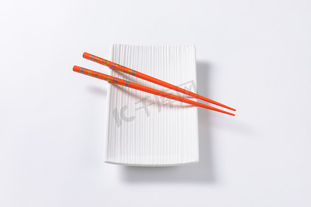 空寿司盘上的橙色筷子