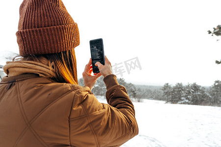 雪免费摄影照片_穿着冬季保暖夹克的女人在多雪的冬季森林里行走