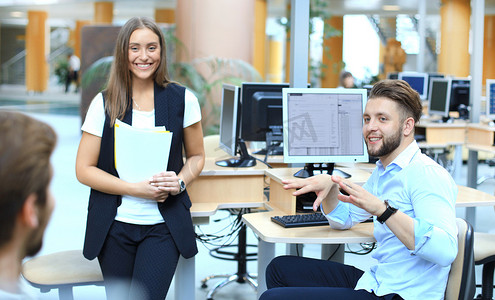 一群年轻自信的商人在办公室里花时间使用计算机分析数据。
