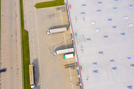 码头货运摄影照片_带有卡车和集装箱的仓储和货运码头鸟瞰图。