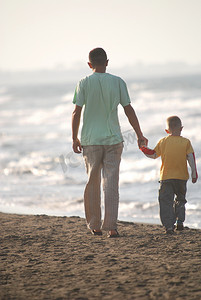 父亲和儿子在沙滩上散步