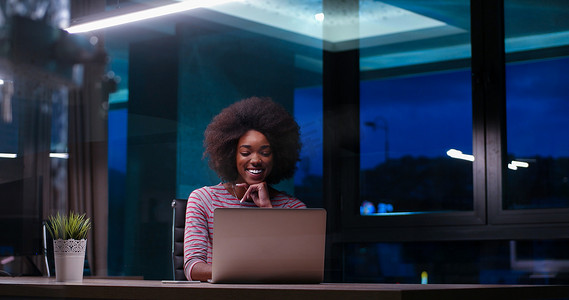 在夜间启动办公室使用笔记本电脑的黑人女商人