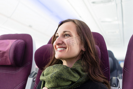 常客摄影照片_飞机飞行期间快乐的女人