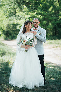 新娘和新郎在森林和岩石的大自然中以灰粉色的婚礼照片。