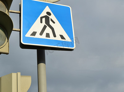 多云天空背景下的人行横道和红绿灯标志，道路安全的概念