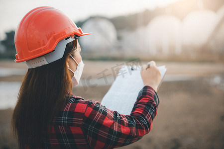 石油化工工人中快乐的亚洲女工在工厂的剪贴板上工作目视检查清单