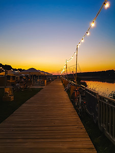 奥德拉河旁边的小海滩酒吧上美丽的日落，周围布满了小装饰灯泡