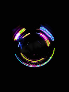 彩色光波摄影照片_深色背景中的彩色圆圈光波
