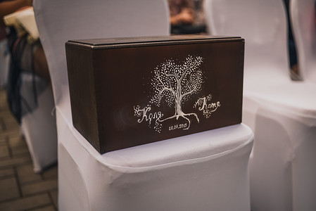 一个棕色的盒子，里面装着涂有白色油漆的礼品信封