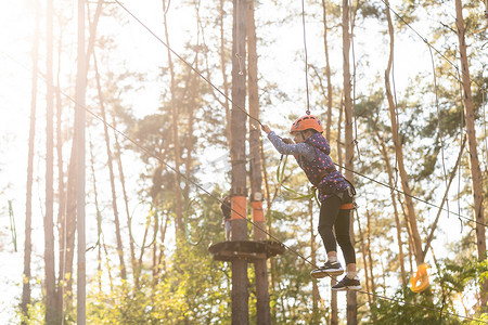 冒险乐园中的女孩攀爬是一个可以包含多种元素的地方，例如绳索攀爬练习、障碍训练场和高空滑索。