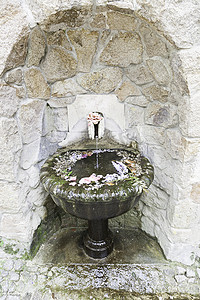 有花的老石喷泉