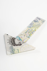 白色货币符号摄影照片_白色背景下英镑钞票的箭头符号