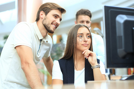 一群自信的年轻商人在办公室里花时间使用计算机分析数据。