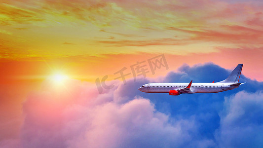 飞机在夕阳的光芒下飞过云层。