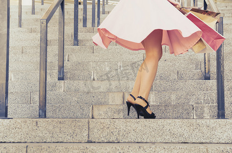 一个穿裙子的女孩拿着纸包在楼梯上旋转
