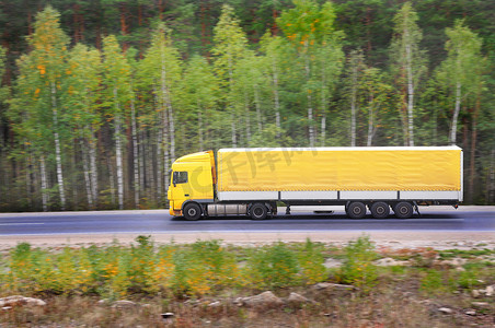 大货车司机摄影照片_黄色拖车在高速公路上行驶