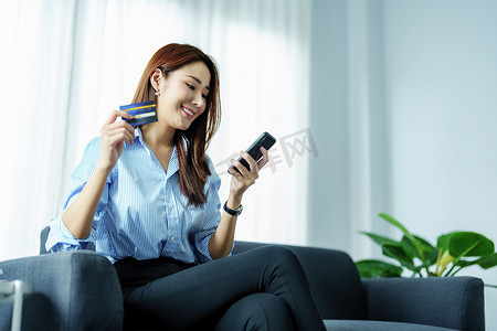 办事指南摄影照片_在线购物和互联网支付，亚洲女性肖像正在使用手机和信用卡在线购物或在数字世界中办事。