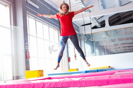 健身、娱乐、休闲和体育活动概念 — 年轻快乐的女人在室内跳蹦床
