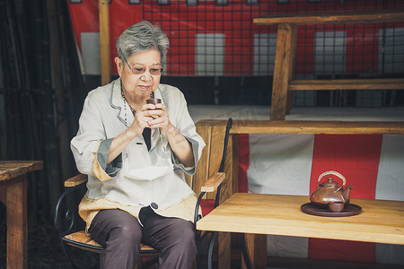 亚洲老年女性老年妇女在花园里喝茶。