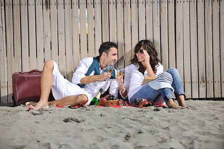 年轻夫妇在沙滩上享受野餐