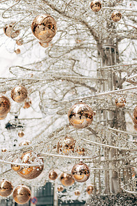 白色玻璃圣诞树上的金色光泽圣诞球。