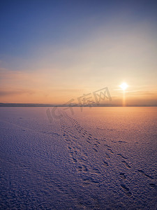 背景河流摄影照片_在一个冬天的早晨，日落在一条结冰和积雪的河流上。