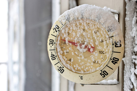 在极冷、寒冷的冬日，冰雪覆盖的室外温度计