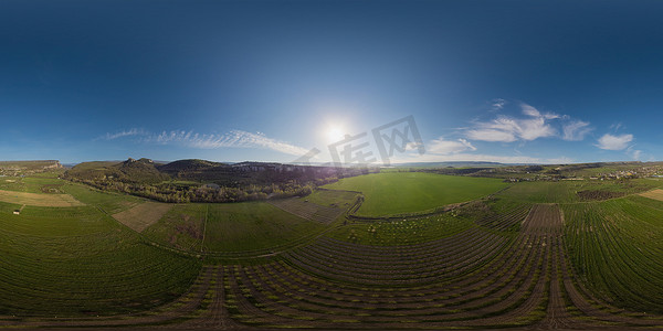 绿色麦田摄影照片_日落时在乡村的年轻花园和绿色麦田的空中全景。