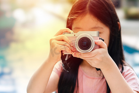 儿童摄影师摄影照片_亚洲儿童拿着相机拍照说明旅行