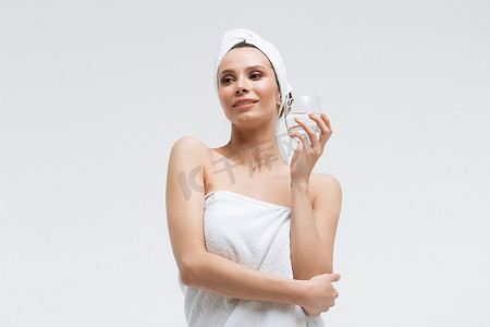 自信放松的女人，头上戴着白毛巾，喝着纯净水，看着别处