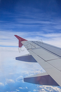喷气式飞机机翼的视图有云彩和蓝天的