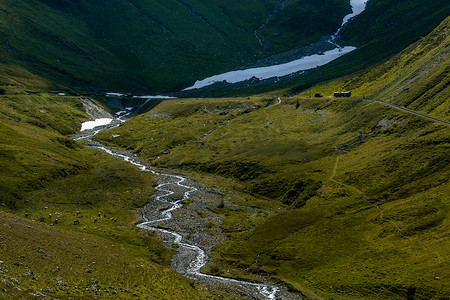 青翠摄影照片_青翠的山谷，蜿蜒的河流从更上游的冰川开始，奶牛在谷底吃草。