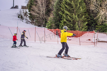 妈妈和儿子正在跟着教练学习滑雪。