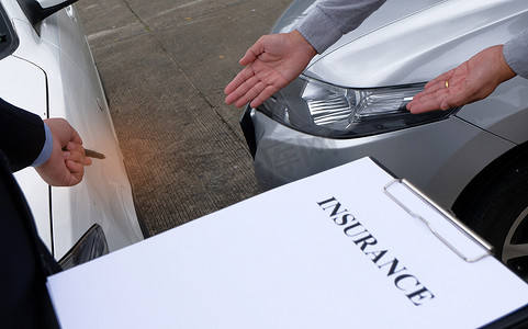 损失理算员保险代理人检查损坏的汽车。